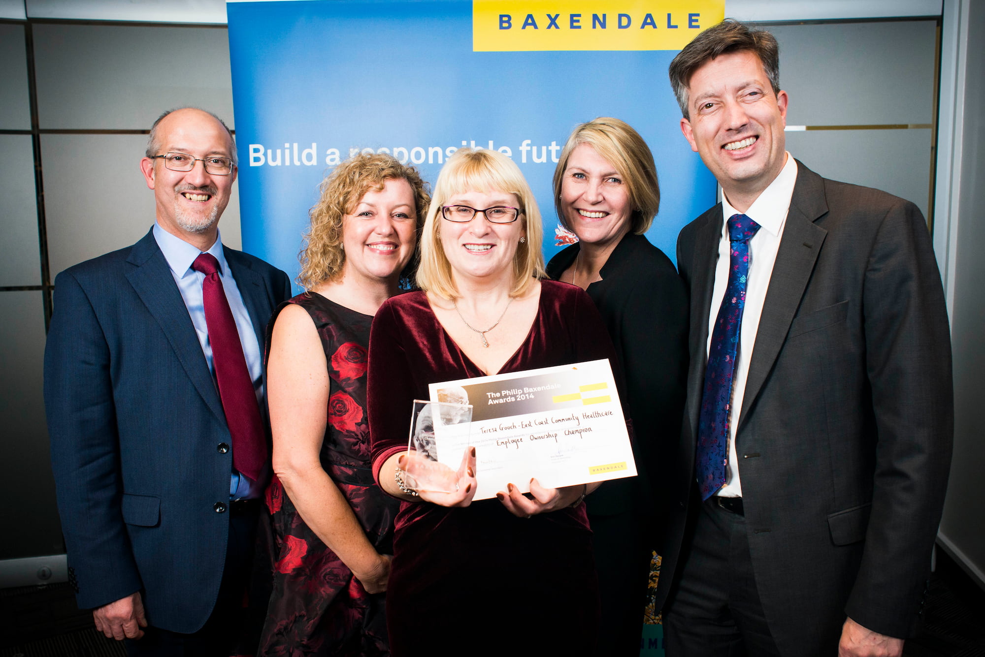 Staff posing for picture presenting a Employee Owndership Award 