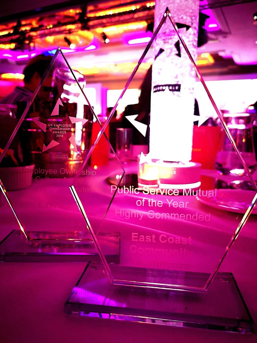 two glass awards/ trophies sitting on a table